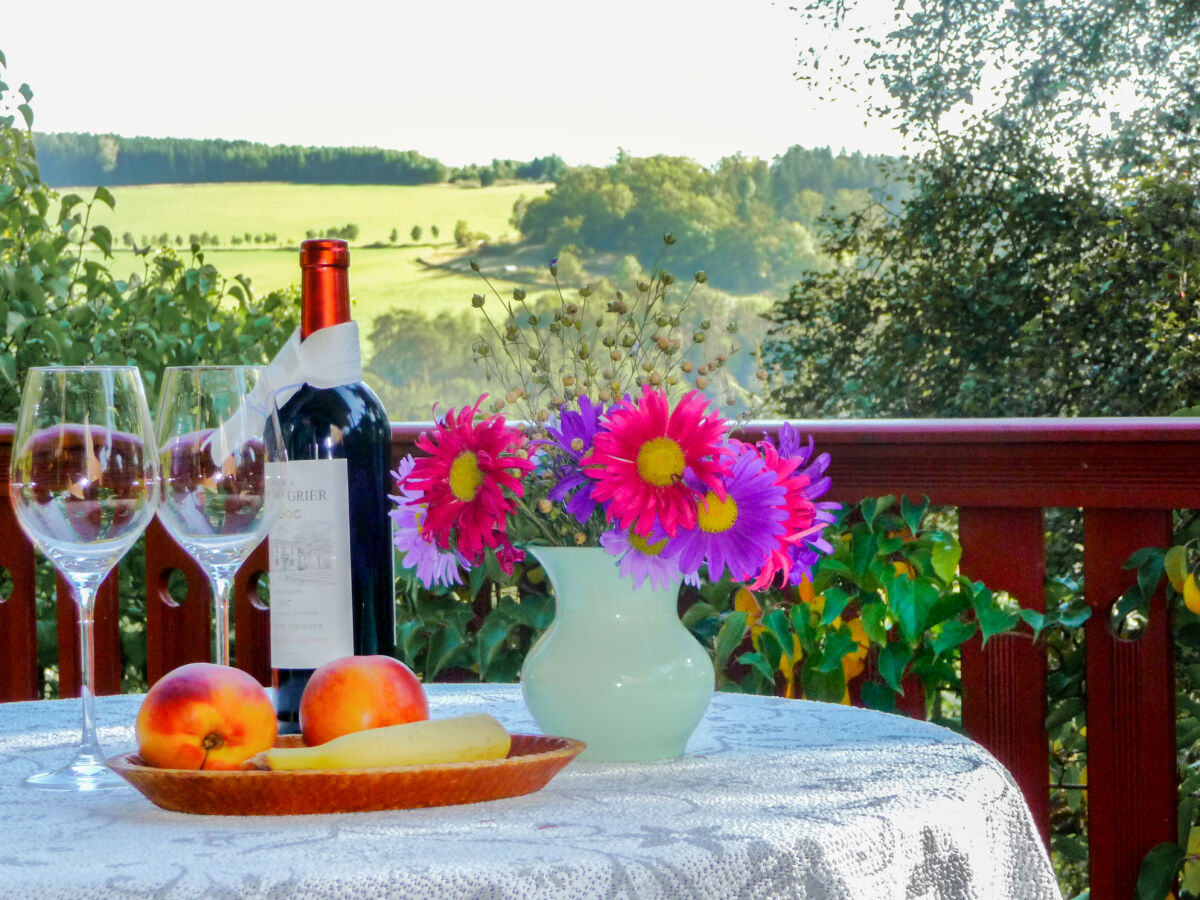 Tisch mit Obst und Wein vor Landschaft